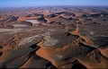 <center>Aussi loin que porte le regard, je découvre la beauté mystérieuse des dunes du Namib. Les transversales s'étendent perpendiculairement aux vents dominants du sud-ouest, c'est aux multidirectionnels que les étoilées doivent leur géométrie. Soumises aux unidirectionnels les dunes barkhanes sont les plus mobiles de toutes ; l'ancienne ville minière de Kolmanskop en témoigne, ensevelie sous leur sable.

 vu du ciel les dunes de la côtes des squelettes namibie 