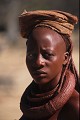 Un visage fin, et des parures très lourdes.
Cette coiffure très en arrière afin de pouvoir transporter les affaires, lors de déplacements. Regard de femme Himba. Parure, collier, chapeau.KAOKOLAND. NAMIBIE 